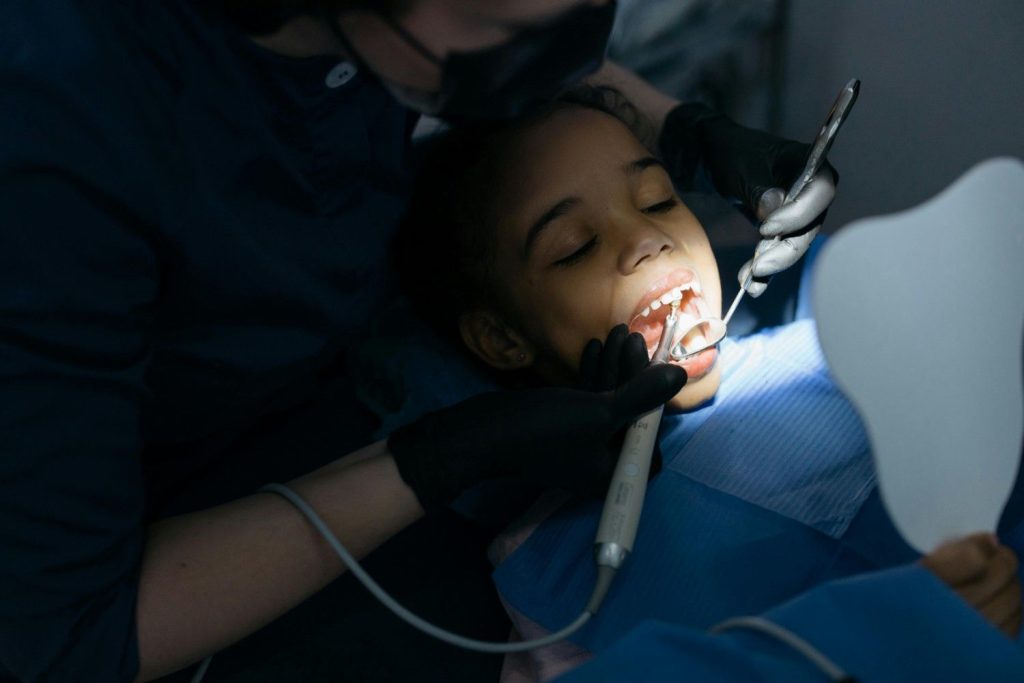 Dentist examining a child’s teeth during pediatric cavity treatment