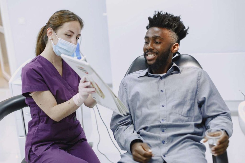 Dentist showing a patient diagnostic information during an exam, illustrating how dental visits can reveal early signs of sleep apnea.