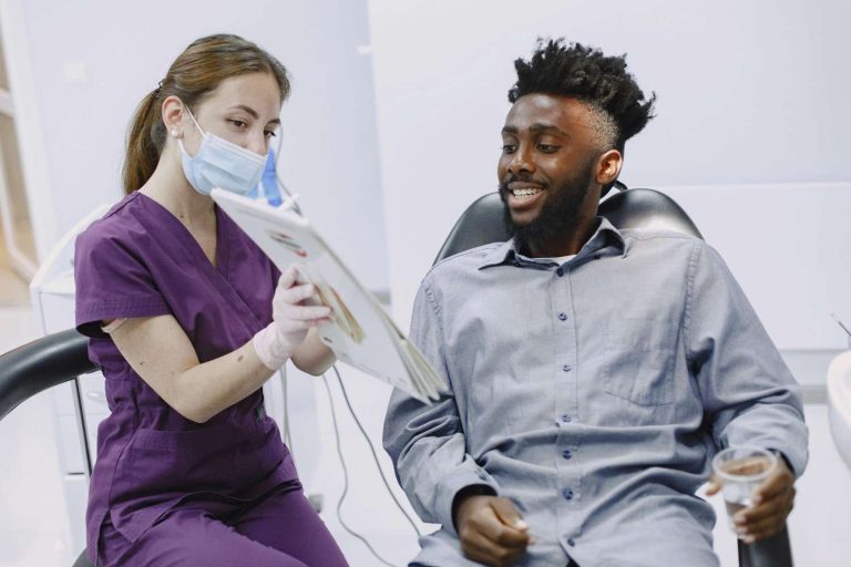 Dentist showing a patient diagnostic information during an exam, illustrating how dental visits can reveal early signs of sleep apnea.